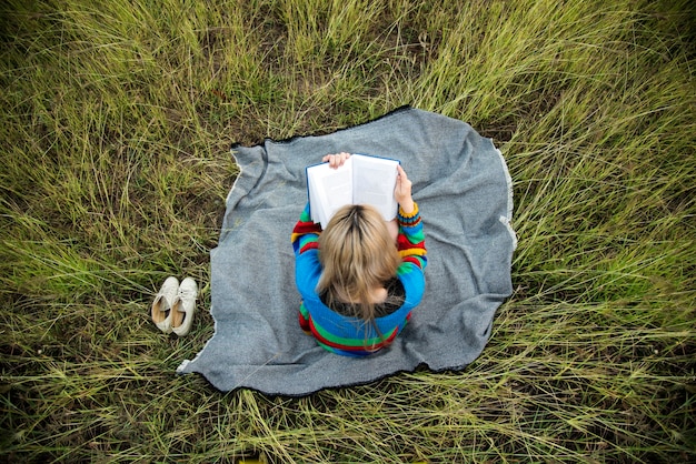 Foto gratuita libro de lectura de mujer en medio de un campo