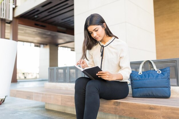 Libro de lectura profesional joven mientras está sentado en el bolso