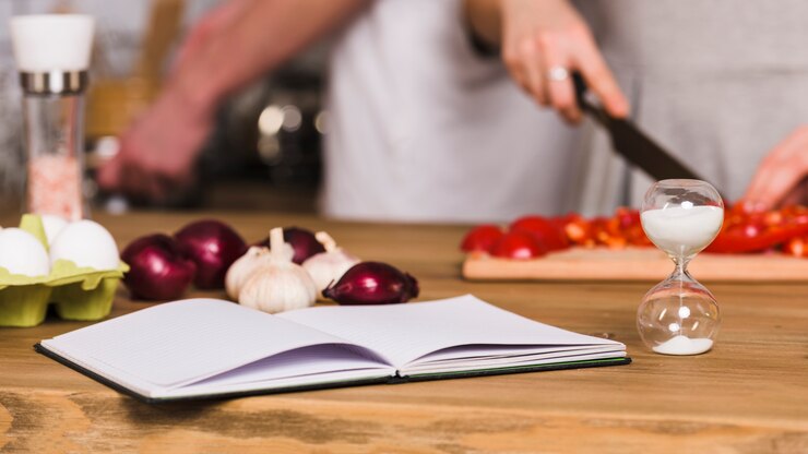 Foto gratuito libro de recetas y reloj de arena en la cocina.