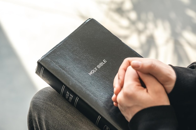 Foto gratuita libro sagrado de la biblia del primer en manos masculinas