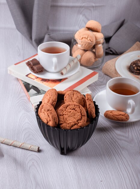 Libro, taza de té y bocadillos dulces.