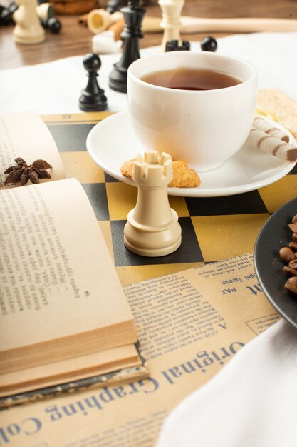 Un libro, una taza de té y una torre de ajedrez.