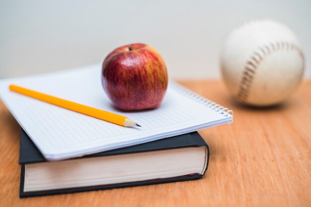 Libro de texto y cuaderno con manzana