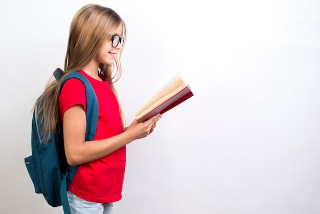 Foto gratuita libro de texto de lectura de colegiala inteligente