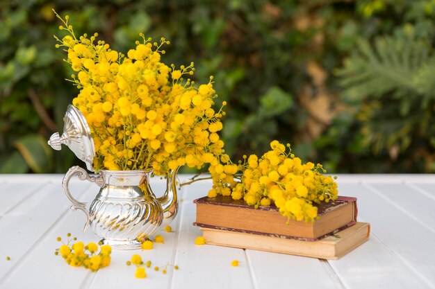 Libros antiguos junto a una tetera con flores