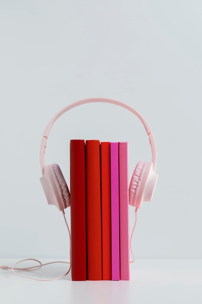 Foto gratuita libros coloridos con auriculares rosa