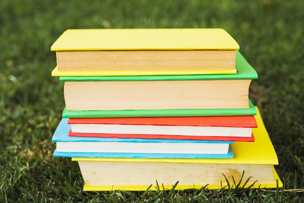 Foto gratuita libros con cubiertas brillantes en blanco sobre hierba