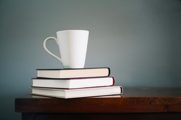 Libros y taza en el gabinete