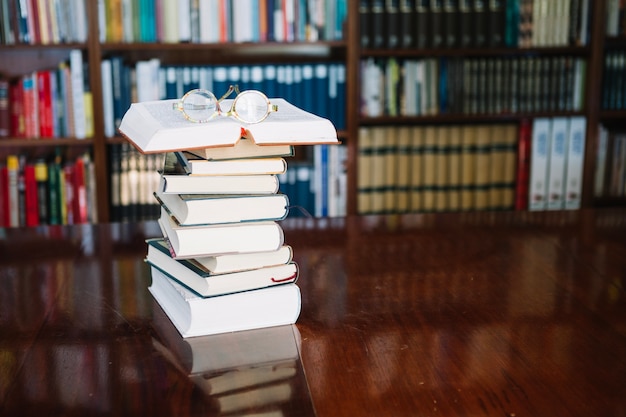 Libros y vasos en la mesa de la biblioteca