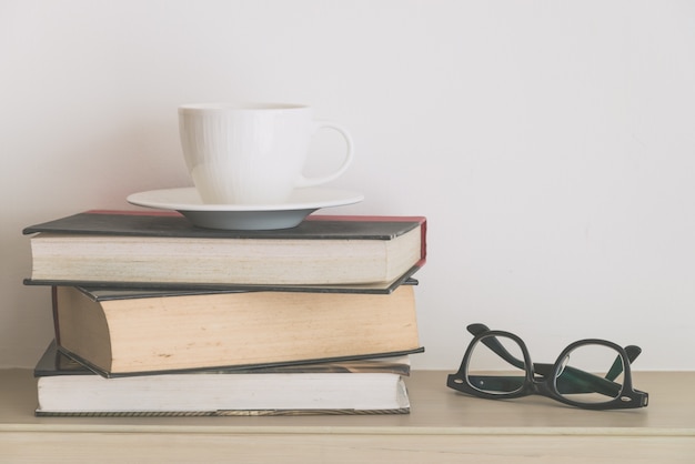 Libros viejos con una taza y gafas