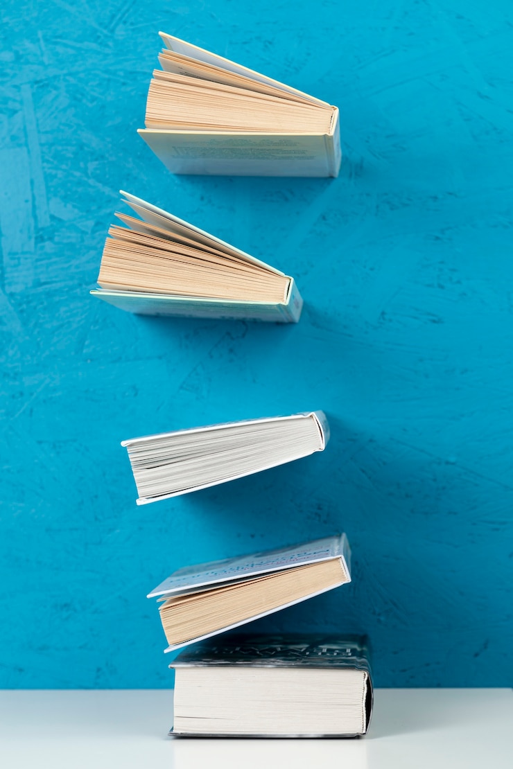 Foto gratuito libros en vista del frente con fondo azul