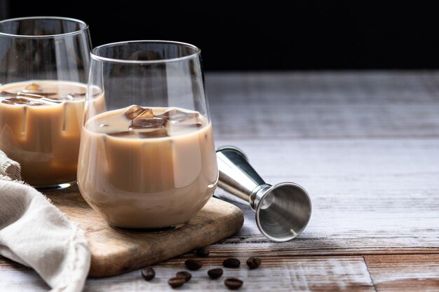 Licor de café con crema tradicional irlandesa con hielo sobre una mesa de madera