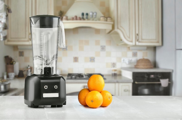 La licuadora eléctrica para hacer jugo de frutas o batidos en la mesa de la cocina. El concepto de una dieta saludable.