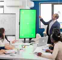 Foto gratuita líder de la empresa que presenta el plan financiero utilizando una pantalla de maqueta frente a una lluvia de ideas de diversos equipos