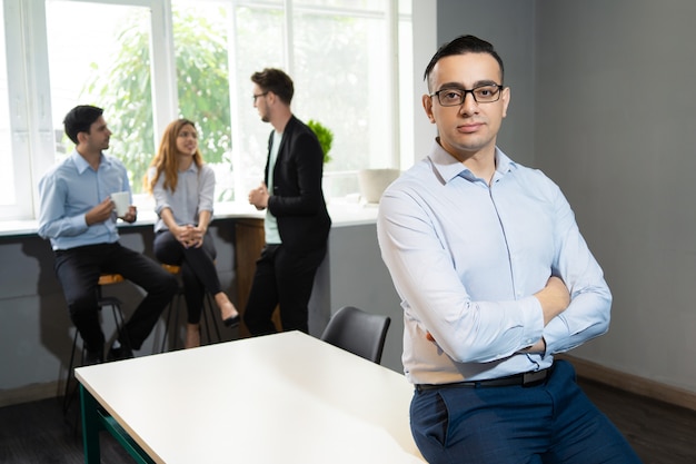 Líder empresarial guapo confiado posando en la sala de reuniones