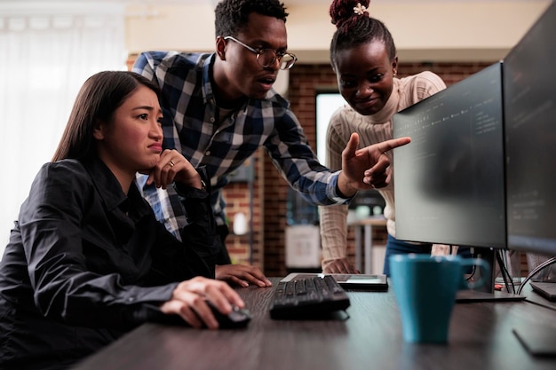 El líder del equipo afroamericano señala anomalías desconocidas en el código de cadena de bloques de la red de seguridad. Equipo de desarrollo multicultural que busca intensamente cambios en la configuración de almacenamiento de la base de datos.