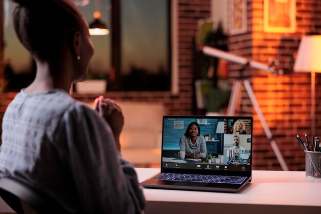 Líder de equipo femenino charlando con compañeros de trabajo en una reunión en línea usando software de videollamada y computadora portátil. Empresarios discutiendo sobre videoconferencia, telecomunicaciones y concepto de trabajo en equipo remoto