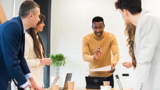 Foto gratuita líder de equipo masculino negro en una reunión de negocios en una oficina