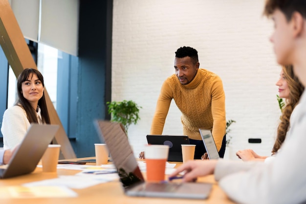 Foto gratuita líder de equipo masculino negro en una reunión de negocios en una oficina