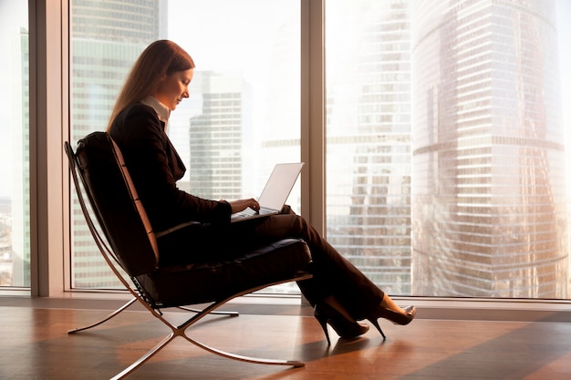 Líder femenino de la empresa trabajando en una computadora portátil en el hotel