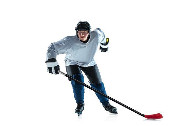 Líder. Jugador de hockey masculino joven con el palo en la cancha de hielo y fondo blanco. Deportista con equipo y casco practicando. Concepto de deporte, estilo de vida saludable, movimiento, movimiento, acción.