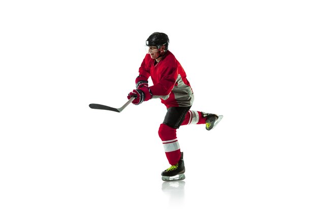 Líder. Jugador de hockey masculino con el palo en la cancha de hielo y fondo blanco. Deportista con equipo y casco practicando. Concepto de deporte, estilo de vida saludable, movimiento, movimiento, acción.