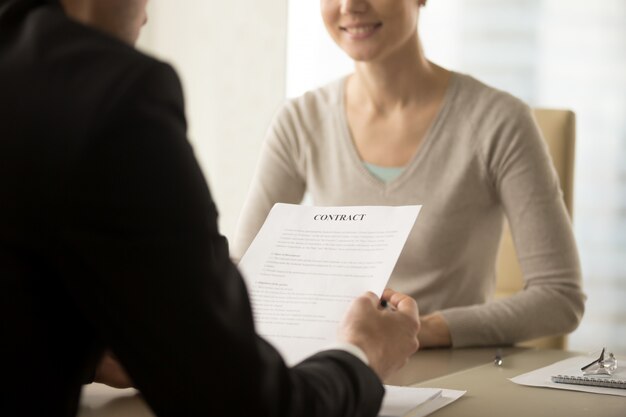 Líderes empresariales femeninos y masculinos estudian contrato