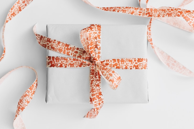 Photo Gratis light gift box with ribbon on white table