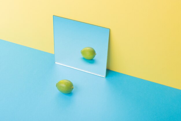 Lima en mesa azul aislado en espejo amarillo cerca