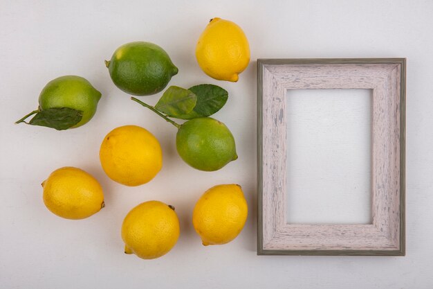 Limas de espacio de copia de vista superior con limones y marco gris sobre fondo blanco