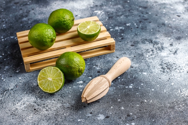 Foto gratuita limas frescas con jugo de cítricos de madera