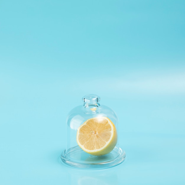 Foto gratuita limón en vidrio sobre fondo azul con espacio de copia
