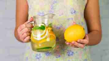 Foto gratuita limonada casera y limon de una mujer.