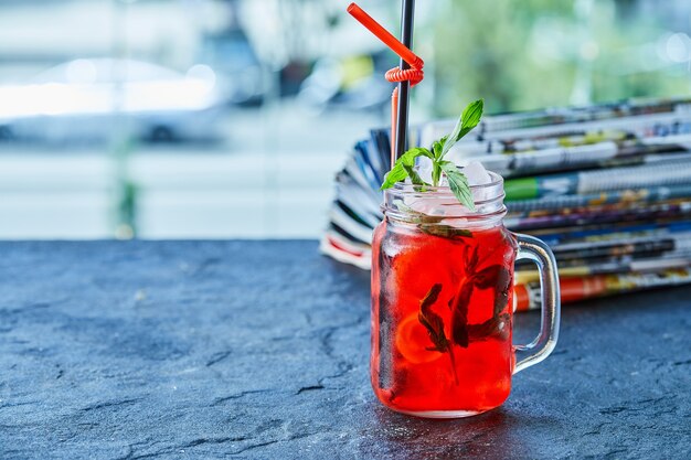 Limonada de fresa con hielo, menta paja en la superficie oscura