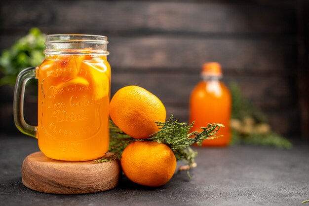 Limonada de naranja fresca vista frontal en vidrio sobre tablero de madera