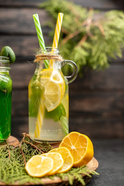 Limonada de vista frontal con feijoa y limón sobre tabla de madera cortada limones en la superficie