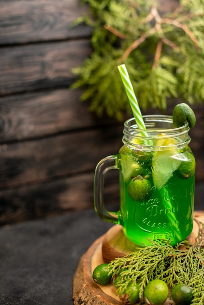 Limonada de vista frontal con feijoa y limón sobre tablero de madera feijoas en superficie