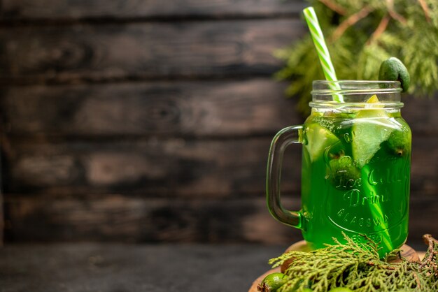 Limonada de vista frontal con feijoa y pipeta de limón sobre tablero de madera feijoas en superficie