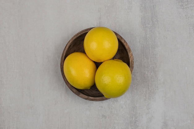 Limones amargos frescos en un tazón de madera.