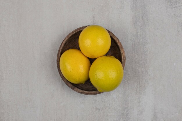 Limones amargos frescos en un tazón de madera.