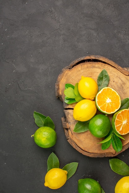 Limones amargos frescos de la vista superior en la cal cítrica de la fruta del piso oscuro