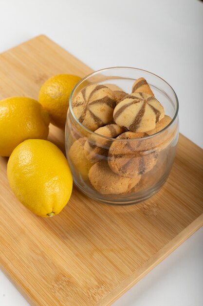 Limones amarillos y galletas en una taza