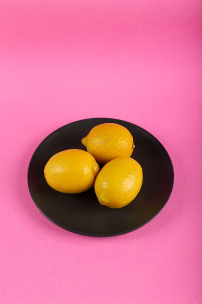 Limones amarillos en un plato negro