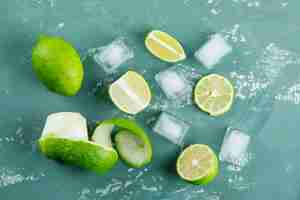 Foto gratuita limones con cáscara, cubitos de hielo planos sobre una tirita