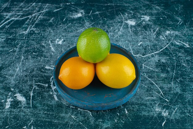 Limones deliciosos en una placa de madera, sobre el fondo de mármol. Foto de alta calidad