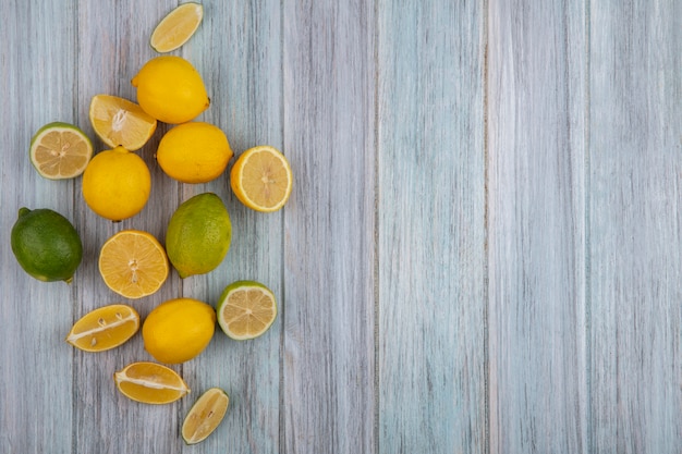 Foto gratuita limones de espacio de copia de vista superior con limón y gajos sobre fondo gris