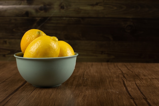 Limones frescos en un recipiente amarillo.