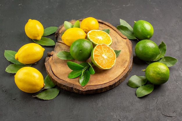 Limones frescos de vista frontal sobre el fondo oscuro