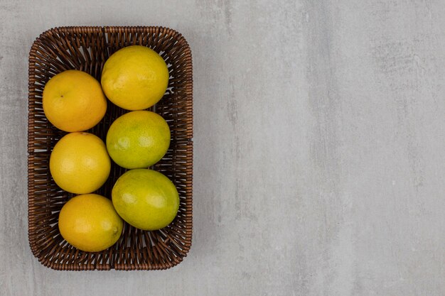 Limones maduros frescos en cesta de madera.