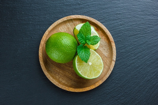 Limones en una placa de madera sobre una superficie de piedra oscura. vista superior. copiar espacio para texto